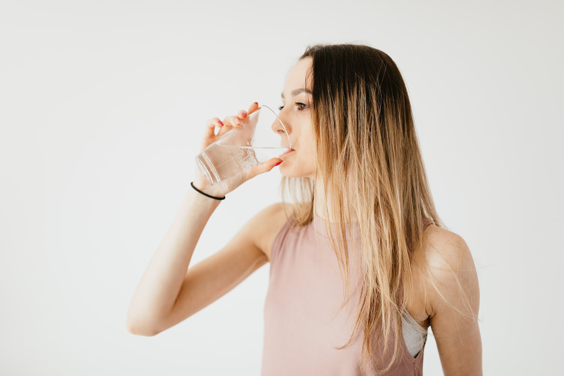 young woman drinking glass of cold pure water